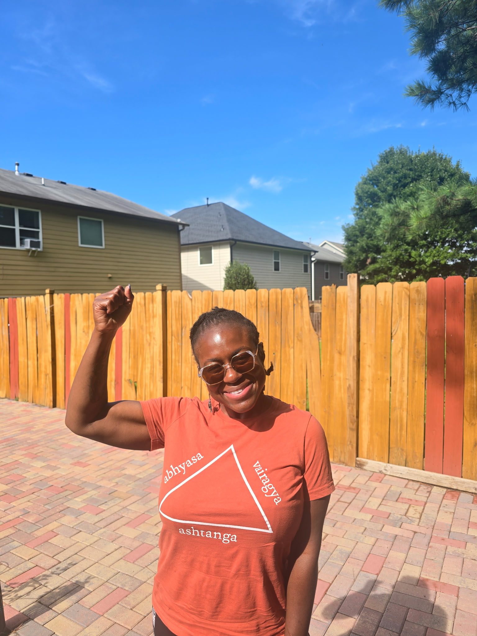 Astride Noel outdoors, flexing her arm and grinning confidently.