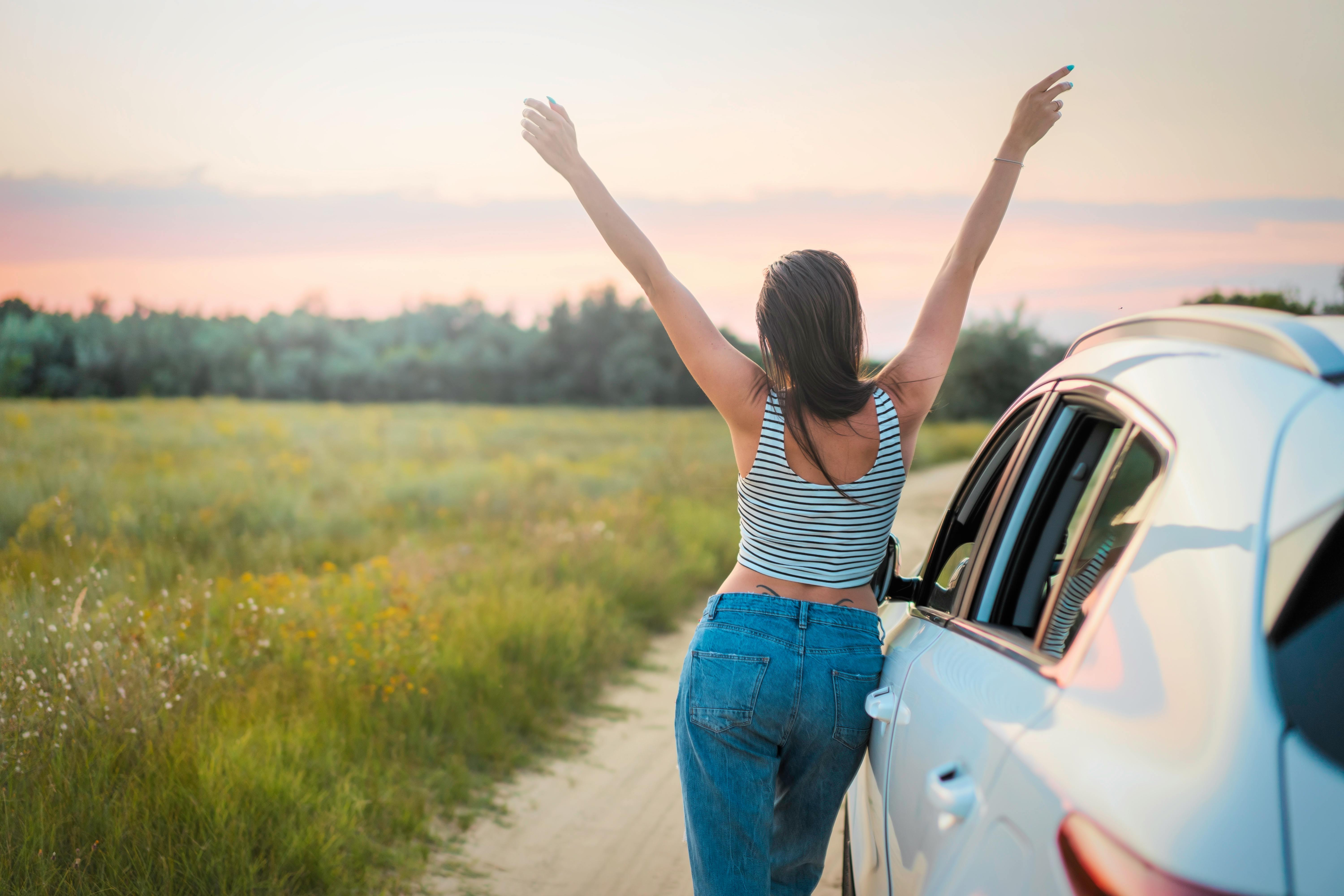 Woman leaning beside vehicle
