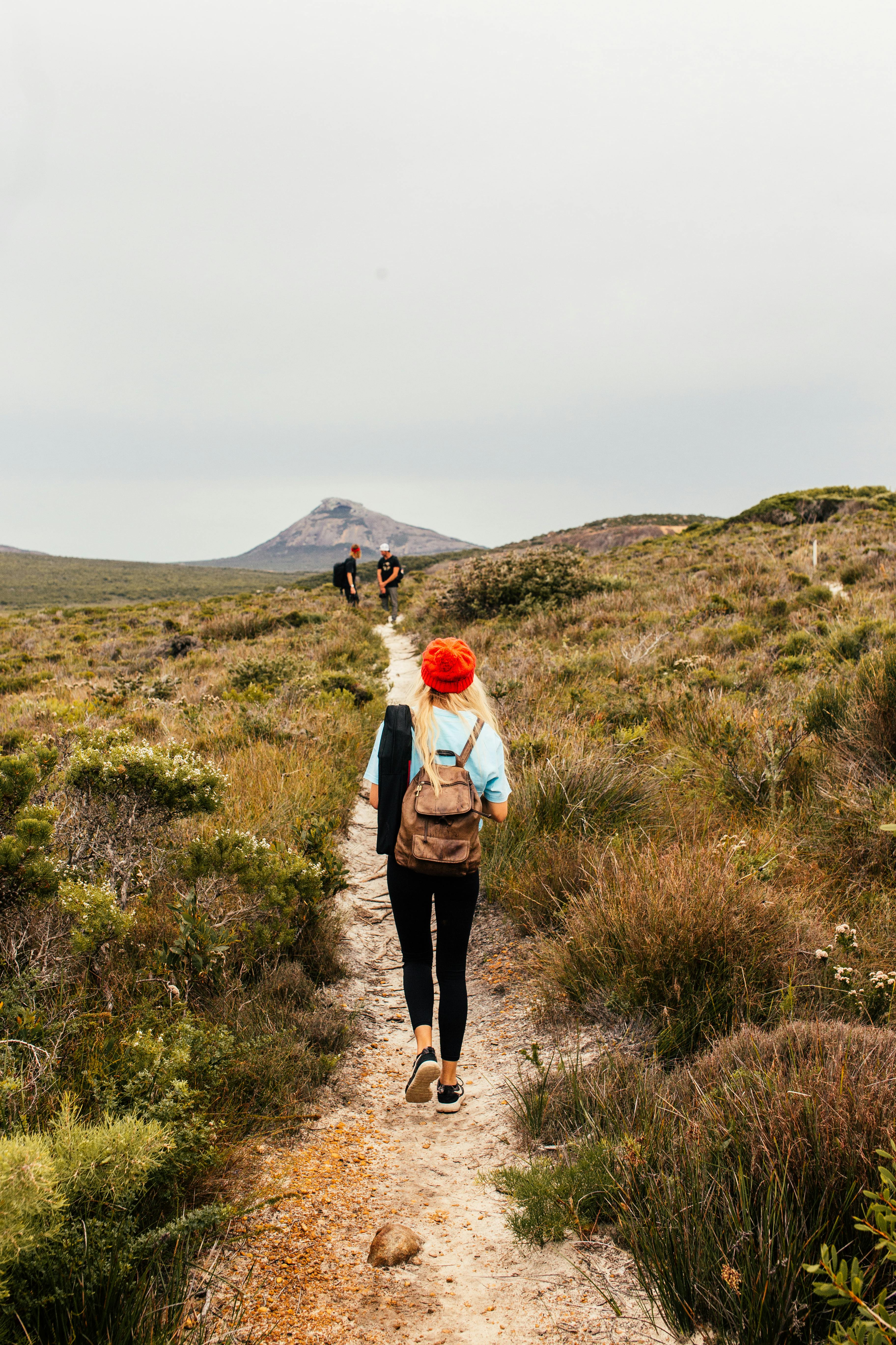 Woman walking a trail with two friends